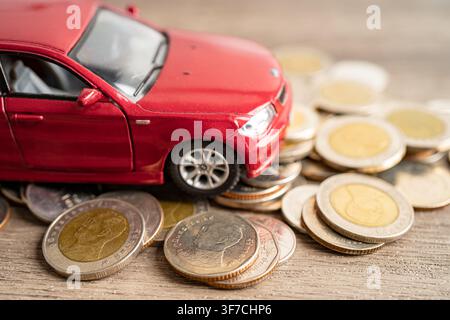 BANGKOK, THAILAND - 12. FEBRUAR 2023, Auto auf Münzen Hintergrund; Autokredit, Finanzen, Sparen, Versicherung und Leasingzeit Konzepte. Stockfoto