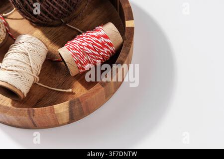 Rustikale Bastelgarn- und Baumwollgarnspulen in Holzschale, Nahaufnahme Stockfoto