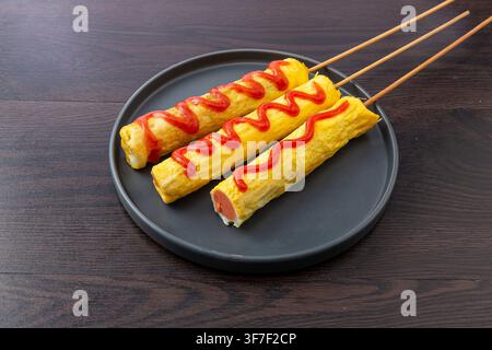 Chinesischer Straßenfood-Stil Gegrillte Wurst in gebratenem Ei gewickelt Stockfoto