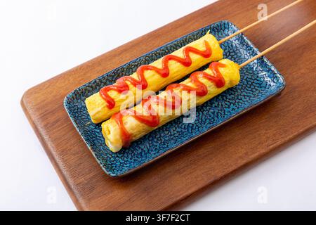 Chinesischer Straßenfood-Stil Gegrillte Wurst in gebratenem Ei gewickelt Stockfoto