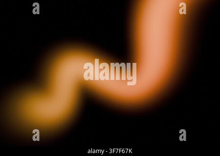 Abstrakter schwarzer Hintergrund mit leuchtender, warmer orangefarbener und goldener gebogener Lichtspur. Weiche Unschärfe und feine Filmkornstruktur für warmes futuristisches Design, Web Stockfoto