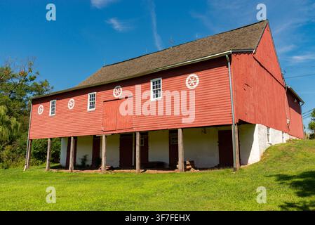 Alte rote Scheune auf offener Feldfläche an einem schönen Sommernachmittag in Pennypacker Mills in Schwenksville, Pennsylvania, USA. Stockfoto