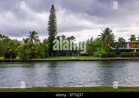 Schöner Blick auf Luxusvillen und tropische Bäume über den Indian Creek Wasserweg in Miami Beach. Miami Beach. USA. Stockfoto