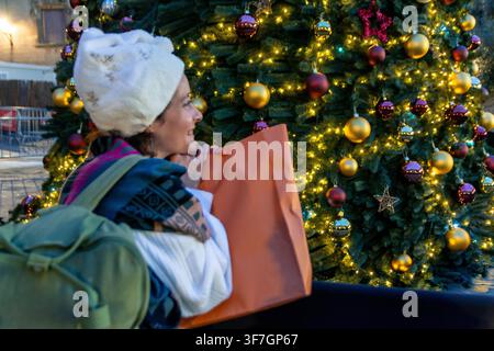 Glückliche Frau genießt Weihnachtseinkäufe in der Stadt Stockfoto