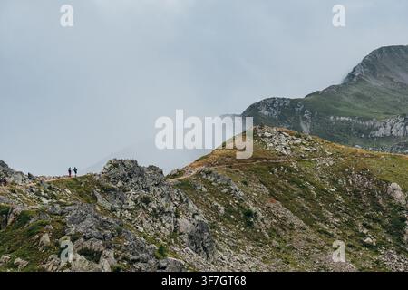 Trekker wandern auf Bergpfad in Richtung Breventgrat in nebliger Alpenlandschaft Französische Alpen Chamonix-Tal Hochgebirghikingroute malerischer Ausblick Stockfoto