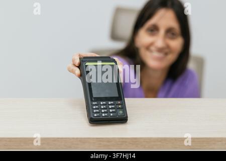 Optiker hält POS-Terminal für die Zahlung Stockfoto