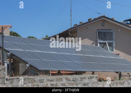 Moderne Solarpanel-Anlage im Hinterhof eines Privathauses. Verwendung alternativer Energiequellen, nachhaltiger Elektrizität und sauberer Technologiesysteme. Stockfoto