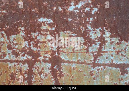 Eisenblechtextur. Verwittertes und oxidiertes rostiges Eisenblech mit abblätternden Farbresten und horizontaler Naht. Industrieller Verfall, Alterung und Grunge-Hintergrund Stockfoto