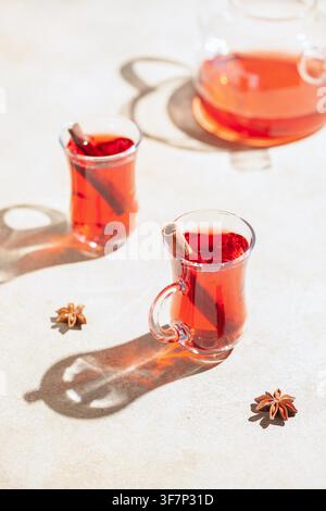Rote Teekarotte in Gläsern Armudu und Gewürze. Hartes Sonnenlicht Stockfoto