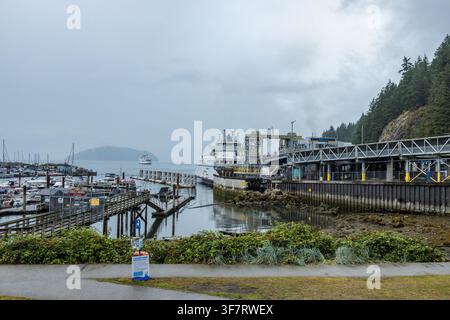 Horseshoe Bay, Kanada – 27. Juli 2026: Ein BC-Ferries-Schiff lädt am Horseshoe-Bay-Terminal, während eine zweite Fähre auf der anderen Seite der Bucht eintrifft, vorbei an einem Yachthafen Stockfoto