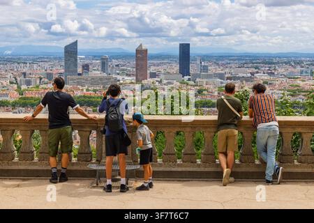 Lyon, Frankreich - 27. Juli 2026: Gruppe von Touristen auf der Terrassenplattform des Hügels Fourviere genießt einen Panoramablick auf die Stadtlandschaft von Lyon und die Wolkenkratzer. Stockfoto