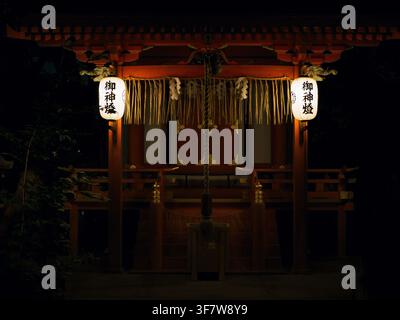 Beleuchteter Shinto-Schrein mit Papierschirmlampen und Shimenawa-Seil bei Nacht, Higashiyama, Kyoto, Japan Stockfoto