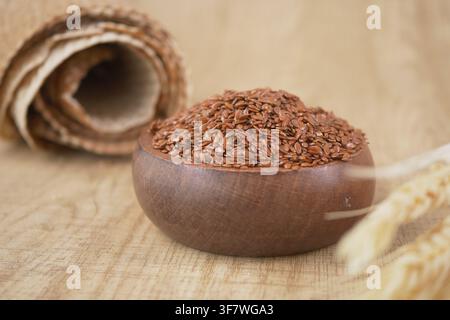 Leinsamen in einer Holzschale auf einer Holzoberfläche Stockfoto