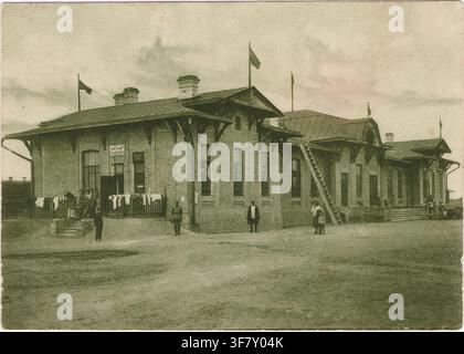 BISCHKEK, KIRGISISTAN — CIRCA 1927: Ein archiviertes Foto aus der frühen Sowjetzeit auf einer Vintage-Postkarte, das das ursprüngliche Backsteingebäude des Bahnhofs zeigt Stockfoto