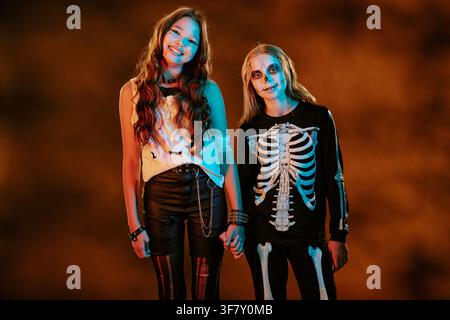 Porträt von vielfältigen Kindern in Halloween-Kostümen, die Händchen halten Stockfoto