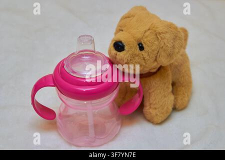 Plastik-Trinkflasche für Kinder mit einem Stofftier Stockfoto