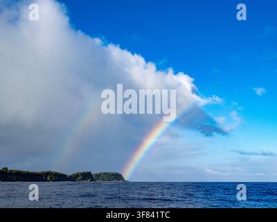 Doppelter Regenbogen erscheint über dem Meer in der Nähe einer Insel an einem klaren Tag in Tonga Stockfoto