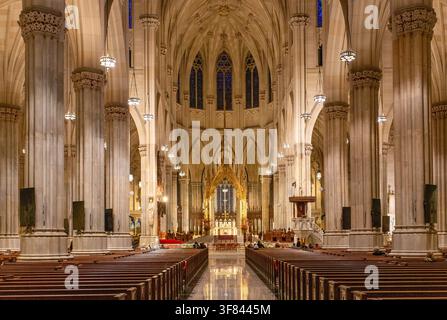 Das Kirchenschiff der St. Patricks Cathedral zeigt seine Architektur und das lange Schiff, das zum Altar in New York City führt Stockfoto