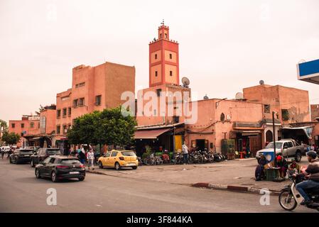 Straßenansicht mit korallenroten Gebäuden und der Kasbah-Moschee in Marrakesch, Marokko, mit lokaler Lebensweise im Blick Stockfoto