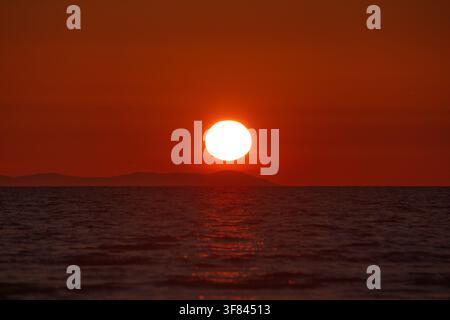 Sonnenuntergang über der Irischen See von Walney Island mit Blick auf die Isle of Man entlang der Küste von Cumbria Stockfoto