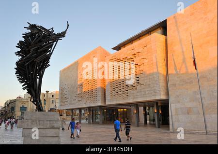 Das Neue Parlamentsgebäude in Valletta präsentiert ein modernes Design und eine nahegelegene Skulptur von Renzo Piano in einem geschäftigen Stadtgebiet während des Sonnenuntergangs Stockfoto