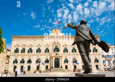 Die Statue von Manwel Dimech steht am Castille-Platz mit der Auberge de Castille im Hintergrund in Valletta, Malta Stockfoto
