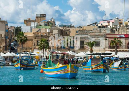 Erkundung von Luzzu-Fischbooten im Hafen von Marsaxlokk, Malta um die Mittagszeit Stockfoto