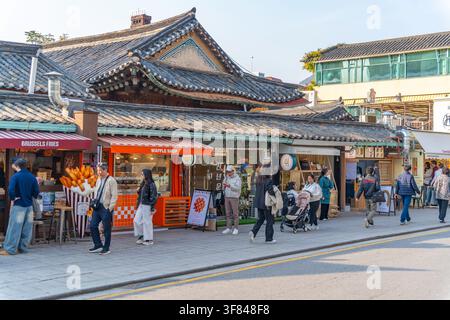 Shops öffnen sich tagsüber im Hanok Village im Yongsan District, Seoul, Südkorea, während Menschen die Straße entlanggehen Stockfoto
