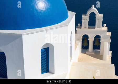Blaue Kuppel und Glockenturm der orthodoxen Kirche in Oia, gesehen von oben auf der Insel Santorin in Griechenland Stockfoto