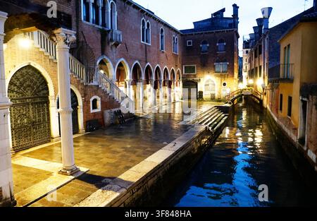 Das Abendlicht spiegelt sich im ruhigen Kanal in Venedig wider, während Gebäude das Wasser umgeben Stockfoto