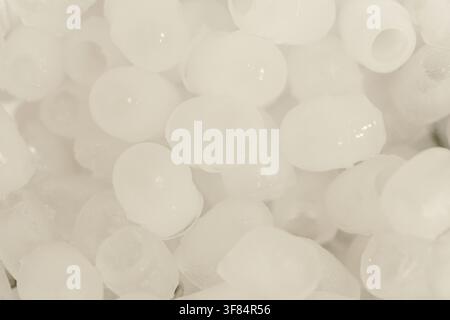 Runde Eiswürfel in einem Kunststoff-Eisbehälter gelagert, bereit für kalte Getränke. Nahaufnahme der Textur von gefrorenem Eis zur Getränkezubereitung. Stockfoto