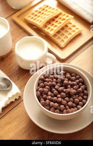 Leckerer Frühstück. Schokoladen-Müsli-Bällchen und Waffeln auf Holztablett serviert, Nahaufnahme Stockfoto