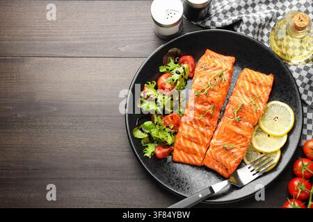 Stücke gegrillten Lachses, serviert mit Salat auf Holztablett, Flat Lay. Platz für Text Stockfoto