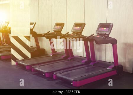 Cardio-Zone mit Laufbändern in einem sonnendurchfluteten Fitnessstudio, selektive Schärfe Stockfoto