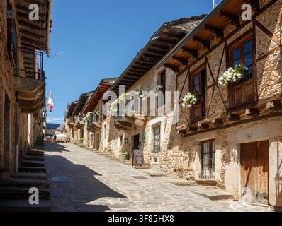 Puebla de Sanabria, Spanien – 07. August 2026: Blick auf die Hauptstraße in Puebla de Sanabria, Spanien, mit historischen Häusern und blumengeschmückten Balkonen Stockfoto