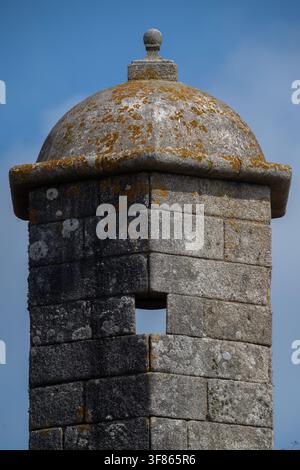 Ansicht des Wachtturms einer historischen Steinbefestigung mit verwittertem Mauerwerk und Flechten vor einem klaren blauen Himmel in Matosinhos, Bezirk Porto, Portugal. Stockfoto