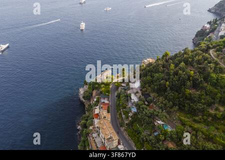 Luftbild der Küstenstadt mit ihren historischen Gebäuden, gewundenen Straßen und üppigen grünen Klippen, die das Tyrrhenische Meer in Atrani, Amalfi Coa überblicken Stockfoto