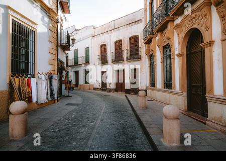 Winding Kopfsteinpflasterstraße im historischen Zentrum von Ronda, Spanien, mit traditioneller andalusischer Architektur und weißen Mauern Stockfoto