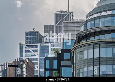 Ansicht moderner Bürogebäude aus Glas und Stahl in Shoreditch mit reflektierenden Fassaden und geometrischen architektonischen Details unter einem bewölkten Himmel in London Stockfoto