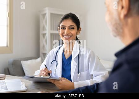 Porträt einer lächelnden südasiatischen Ärztin, die einen männlichen Patienten berät Stockfoto