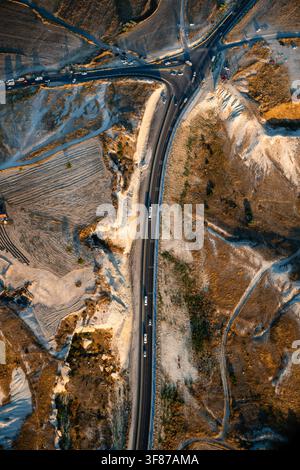 Luftaufnahme einer gewundenen Straße durch die Landschaft der Kappadokien in der Nähe von Göreme, Nevşehir, Türkei Stockfoto