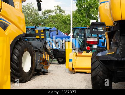 Große moderne Traktoren und Mähdrescher, die auf einer Landwirtschaftsmaschinenmesse ausgestellt sind, präsentieren fortschrittliche landwirtschaftliche Geräte und Mechanisierung. Stockfoto