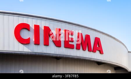 Nahaufnahme des großen "Kino"-Schilds eines Kinos in roten Großbuchstaben an einem sonnigen Tag Stockfoto