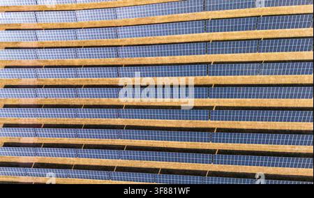 Geometrische Luftbilddrohnenansicht von photovoltaischen Solarpanelen auf einer großflächigen Solarfarm in Großbritannien Stockfoto