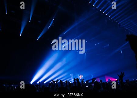 Rjasan, Russland, 28.09.2025 Menge mit erhobenen Händen und Handys bei einem Konzert. Bühnenlichter beleuchten eine Musikaufführung. Live-Event-Erleb Stockfoto