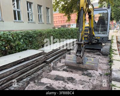 Neuer Fußwegbau mit Betonplatten und Bagger – Konzept für städtische Infrastruktur und Bauingenieurwesen Stockfoto