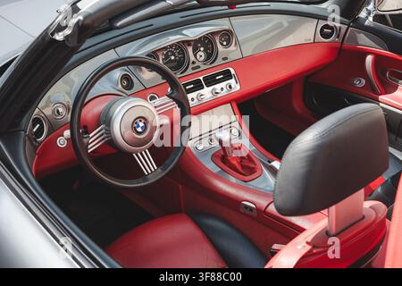 Lindau, Schweiz, 9. August 2026. Hochwinklige Innenansicht eines silbernen BMW Z8 Roadsters mit Retro-Lenkrad, roten Ledersitzen, Schalthebel, Stockfoto