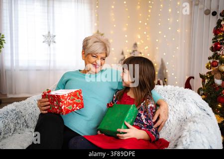 Großmutter und Enkelin tauschen Geschenke während der Weihnachtsfeiertage aus Stockfoto