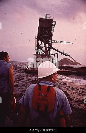 Arbeiter werden zu Baggern transportiert, die als Teil des DOCUMERICA-Programms der Environmental Protection Agency den Seegrund reinigen, 1. Mai 1972. Stockfoto