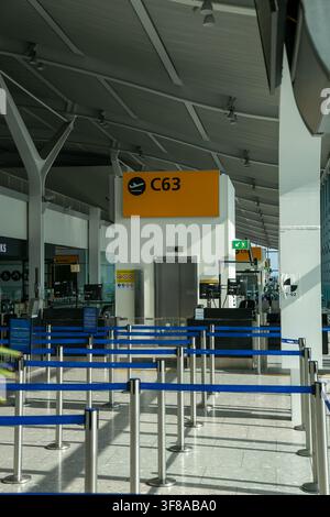 Boardingsgate C63 im Terminal 5C am Flughafen London Heathrow (LHR), Vereinigtes Königreich. Der Gatebereich des Flughafens verfügt über Passagier-Schlangenbarrieren Stockfoto